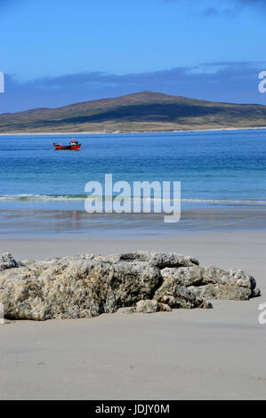 Eine kleine rote Angeln Boot vorbei Weststrand auf der Insel Berneray auf North Uist mit der Insel Pabbay im Hintergrund, äußeren Hebriden, Stockfoto