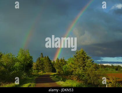 Ein Regenbogen über den Trans Canada Trail oder der Bundes-Trail in ländlichen Prince Edward Island, Kanada. Stockfoto