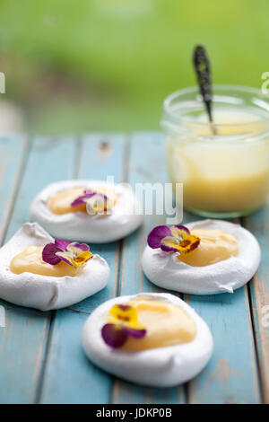 Mini Pavlova mit Lemon Curd und Blumen Stockfoto