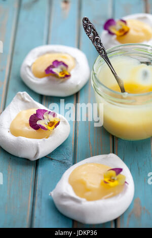 Mini Pavlova mit Lemon Curd und Blumen Stockfoto