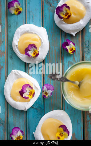 Mini Pavlova mit Lemon Curd und Blumen Stockfoto