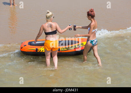 Bournemouth, Dorset, UK. 21. Juni 2017. UK-Wetter: ein weiterer heißer sonniger Tag in Bournemouth Strände, da die Temperaturen steigen um die Hitzewelle und Besucher Kopf ans Meer nach oben bis ihre tans fortzusetzen. Zwei Frauen, die Spaß mit einem Schlauchboot Boot im Meer. Bildnachweis: Carolyn Jenkins/Alamy Live-Nachrichten Stockfoto