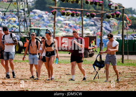 Pilton, Somerset, UK. 21. Juni 2017. Glastonbury Festival Tag 1 - Festival-Gänger in Shorts und t-Shirts an einem heißen Tag mit Zelten in der Backgroung zu Fuß über trockene Schlamm beim Glastonbury Festival, Pilton 21. Juni 2017, UK Credit: DFP Photographic/Alamy Live News Stockfoto