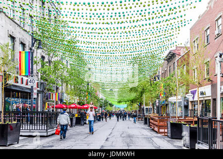 Montreal, Kanada - 26. Mai 2017: Menschen zu Fuß auf Sainte Catherine Street in Montreal Gay Village in Quebec Region mit hängenden Dekorationen Stockfoto