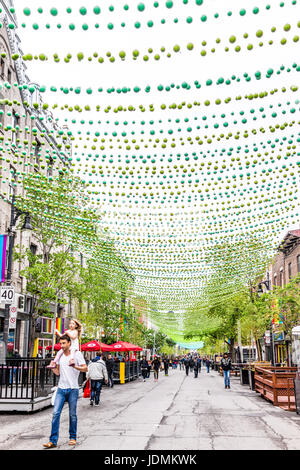 Montreal, Kanada - 26. Mai 2017: Menschen zu Fuß auf Sainte Catherine Street in Montreal Gay Village in Quebec Region mit hängenden Dekorationen Stockfoto