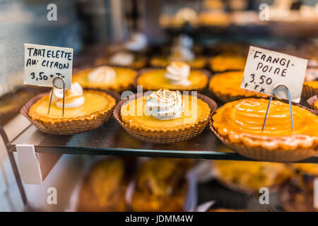 Zitronentorte mit Schlagsahne auf dem Display in der Bäckerei mit Zeichen auf Französisch Stockfoto