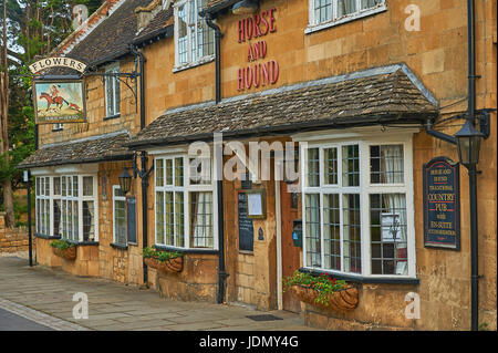 Pferd und Hund Gastwirtschaft in der Cotswold Broadway mit einem alten Pub melden Werbung Blumen Ales Stockfoto