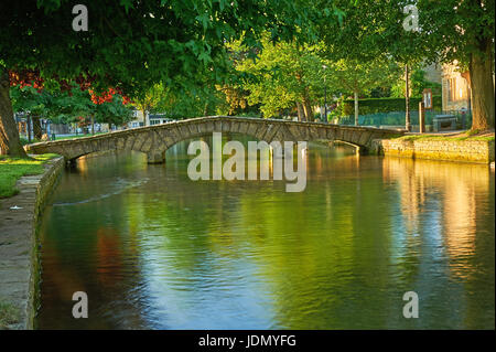 Ein Sommermorgen und kleinen steinernen Stege über den Fluss Windrush im malerischen Cotswolds Dorf von Bourton auf dem Wasser, Gloucestershire Stockfoto