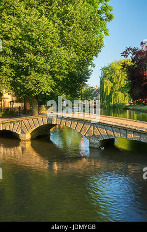 Ein Sommermorgen und kleinen steinernen Stege über den Fluss Windrush im malerischen Cotswolds Dorf von Bourton auf dem Wasser, Gloucestershire Stockfoto