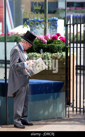 Ein Rennenbesucher liest der Racing Post tagsüber zwei Royal Ascot in Ascot Racecourse. Stockfoto