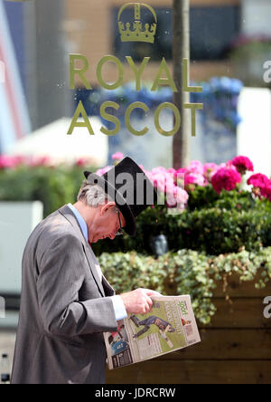 Ein Rennenbesucher liest der Racing Post tagsüber zwei Royal Ascot in Ascot Racecourse. Stockfoto