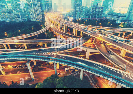 Blick über den berühmten Drachen Autobahnkreuz in Shanghai, China, mit Verkehr. Skyline von Shanghai am Abend. Stockfoto