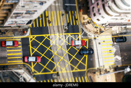 Luftaufnahme von einer Kreuzung in Hong Kong, China, mit Autos und Menschen an einem Sommertag. Luftaufnahme. Stockfoto