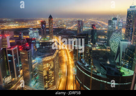 Spektakuläre nächtliche Skyline von Dubai, Vereinigte Arabische Emirate.  Futuristische Architektur einer Großstadt bei Nacht. Blick über Autobahn mit beleuchteten Wolkenkratzern. Stockfoto