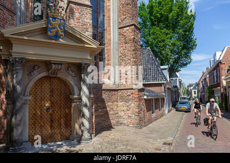 Leeuwarden, Niederlande, 11. Juni 2017: paar auf dem Fahrrad pass orange Veranda des großen oder Jakobiner Kirche in Leeuwarden Stockfoto