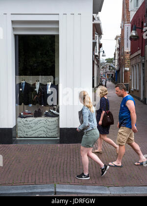 Leeuwarden, Niederlande, 11. Juni 2017: Mann, Frau und Mädchen passieren Herren Mode Shop in Leeuwarden, Hauptstadt von Friesland in den Niederlanden Stockfoto