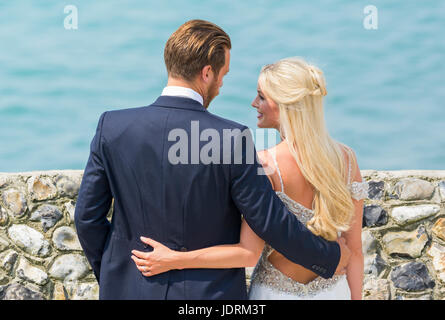 Braut und Bräutigam an einem Strand mit Fotos für ihre Hochzeit. Ehepaar. Zu heiraten. Tag der Ehe. Stockfoto