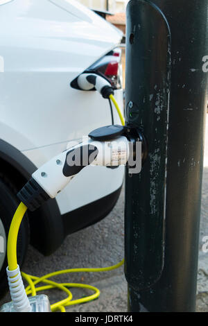 Ein Elektroauto-Ladegerät-Umbau durch Ubitricity: Intelligentes Kabel an einer Straßenlampe, mit dem nun ein Elektroauto von einer Lampenpfosten (in diesem Fall ein Tesla) geladen werden kann. Twickenham UK Stockfoto