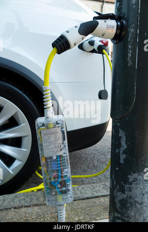 Ein Elektroauto-Ladegerät-Umbau durch Ubitricity: Intelligentes Kabel an einer Straßenlampe, mit dem nun ein Elektroauto von einer Lampenpfosten (in diesem Fall ein Tesla) geladen werden kann. Twickenham UK Stockfoto