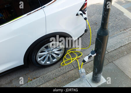 Ein Elektroauto-Ladegerät-Umbau durch Ubitricity: Intelligentes Kabel an einer Straßenlampe, mit dem nun ein Elektroauto von einer Lampenpfosten (in diesem Fall ein Tesla) geladen werden kann. Twickenham UK Stockfoto