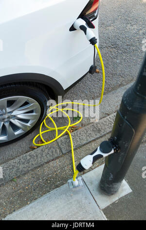 Ein Elektroauto-Ladegerät-Umbau durch Ubitricity: Intelligentes Kabel an einer Straßenlampe, mit dem nun ein Elektroauto von einer Lampenpfosten (in diesem Fall ein Tesla) geladen werden kann. Twickenham UK Stockfoto