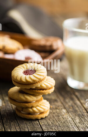 Kekse mit Marmelade auf alten Holztisch. Stockfoto