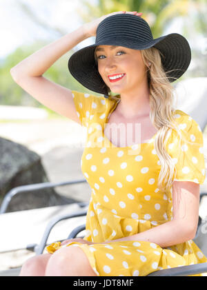 Junge australische Frau in gelb gepunkteten Kleid entspannen am Palm Cove bei Cairns, Queensland, Australien Stockfoto