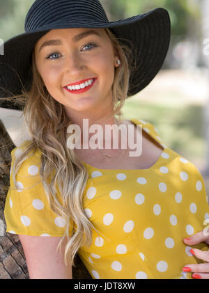 Junge australische Frau in gelb gepunkteten Kleid entspannen am Palm Cove bei Cairns, Queensland, Australien Stockfoto