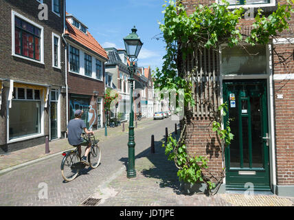 Leeuwarden, Niederlande, 11. Juni 2017: Mann fährt Rad in sonnige Straße im Zentrum von Leeuwarden in den Niederlanden Stockfoto