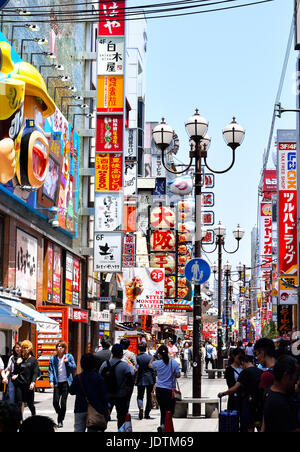 Shopper schlendern Sie durch eine Gasse von Zeichen und Neonröhren in Namba, Osaka, Japan Stockfoto