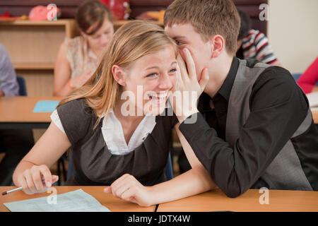 Zwei Studenten teilen sich ein Geheimnis in der Klasse Stockfoto