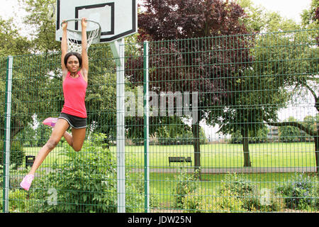 Frau von Basketballkorb hängen Stockfoto