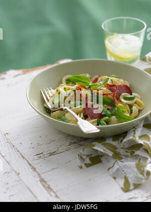 Schüssel mit Orecchiette mit Erbsen und Schinken Stockfoto