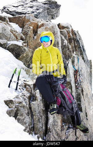 Frau in Kletterausrüstung ruht auf Berg Stockfoto