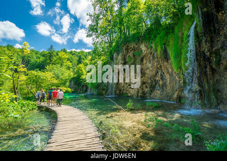 Touristen Fuß entlang der Holzsteg die Winde um Nationalpark Plitvicer Seen