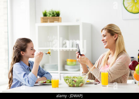 Frau fotografieren Tochter per Smartphone zu Hause Stockfoto