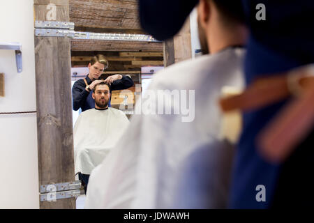 Mann und Friseur Haare schneiden bei Barbershop Stockfoto