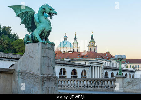 Grüner Drache auf Drachenbrücke in Ljubljana mit Markt und Kirche des Heiligen Nikolaus Stockfoto