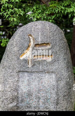 Ren Charakter auf geschnitzten Stein im japanischen Garten Stockfoto