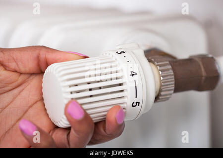 Abgeschnitten Bild Womans Hand Thermostat einstellen Stockfoto