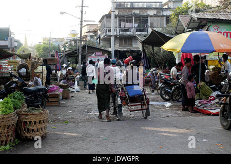 Zegyo Markt/Mandalay - Myanmar 22. Januar 2016: ein Mann treibt seine Rikscha entlang einer Straße am Zegyo Markt mit drin saß eine Frau. Stockfoto