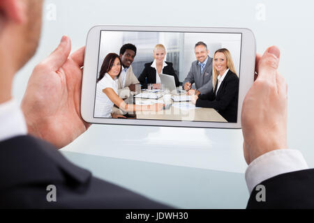 Bild von Geschäftsmann Videokonferenzen auf digital-Tablette am Schreibtisch im Büro beschnitten Stockfoto