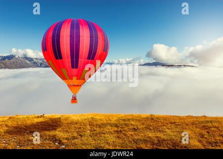 Flug am Morgen von den Heißluftballon über den Bergen. Stockfoto