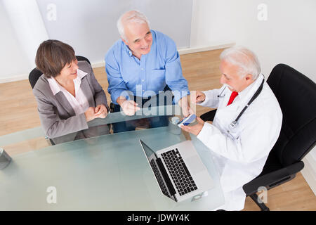 Vogelperspektive Blick auf älteres paar diskutieren über Medizin am Schalter in Klinik Stockfoto