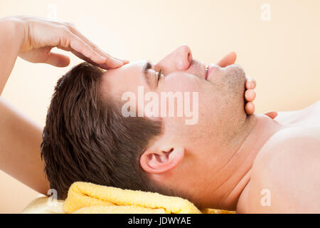 Seitenansicht des jungen Mannes, an die Stirn Massage im spa Stockfoto