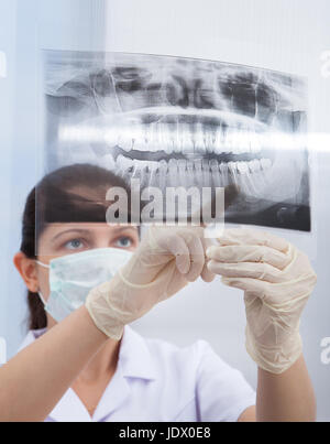 Junge weibliche Zahnarzt zeigte auf Kiefer Xray in Klinik Stockfoto