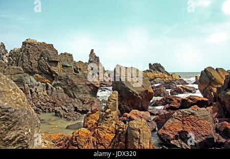 Spiky, robust, und Skulptur Typ Granit Felsformationen an der Küste in Arambol Strand von Goa, Indien Stockfoto