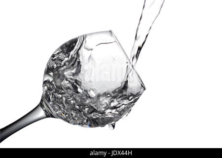 Farblose Flüssigkeit, Wasser wird Wodka in ein Glas Flüssigkeit in einem Lautsprecher, isoliert auf einem weißen Hintergrund gegossen. Stockfoto