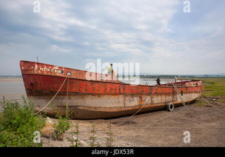 Glasson Dock Estuary & Marina, Lancashire, Großbritannien. Polnische Arbeiter demontieren und verschrotten das zerstörte Fischerboot Mercer. Stockfoto