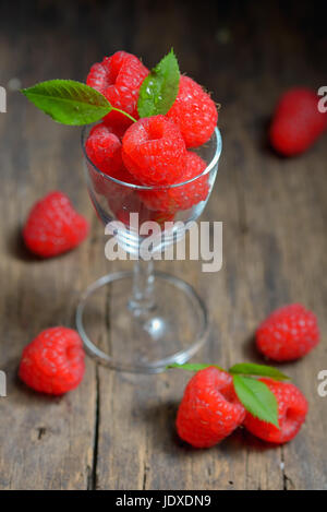 Himbeeren in kleinen Glas auf Holztisch Stockfoto